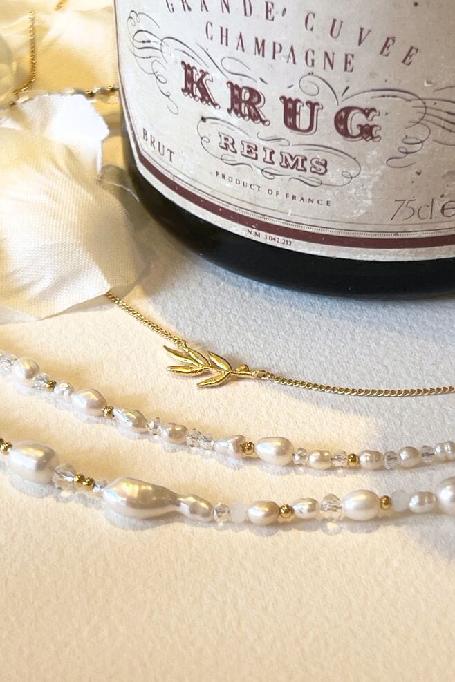 A modern and romantic pearl necklace, featuring an array of dainty Baroque pearls, freshwater pearls, 18k gold plated Silver, and sparkling crystals.