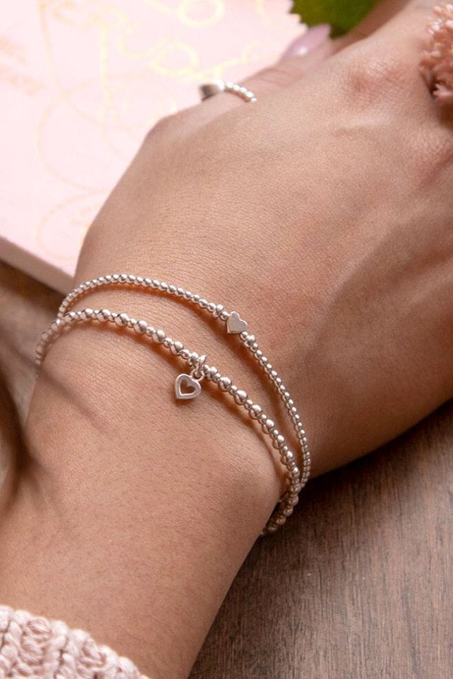 Handcrafted in 925 Sterling Silver, this two-strand stack is detailed with heart charms.