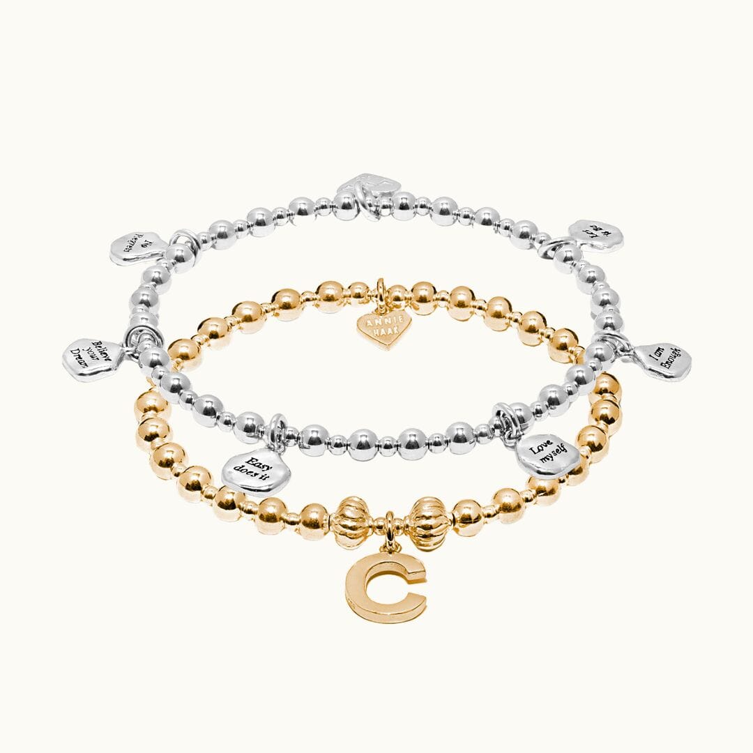Sterling Silver Affirmation charm bracelet stacked with Gold plated Indigo Initial charm bracelet.