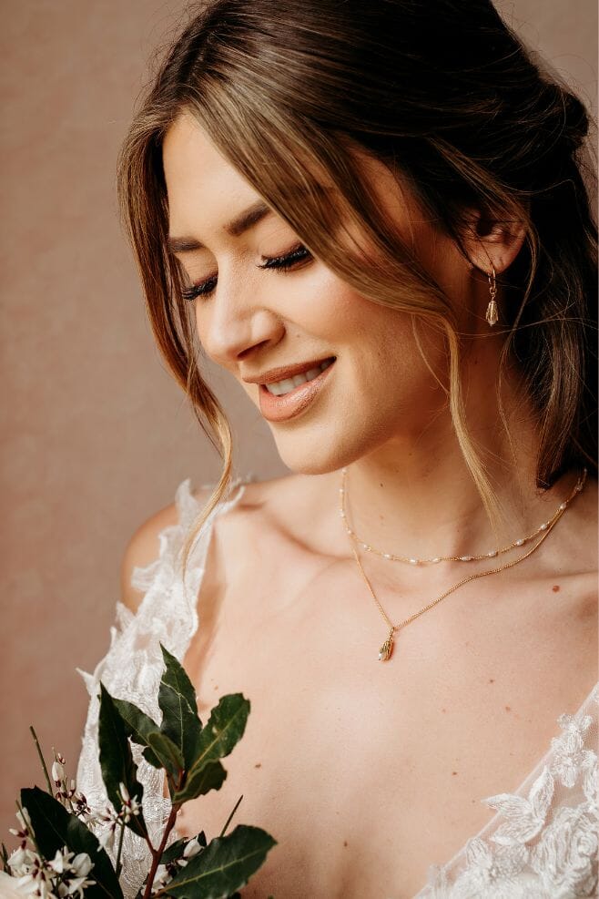A handcrafted 18k gold plated silver necklace, featuring a delicate pearl and detailed leaf pendant.