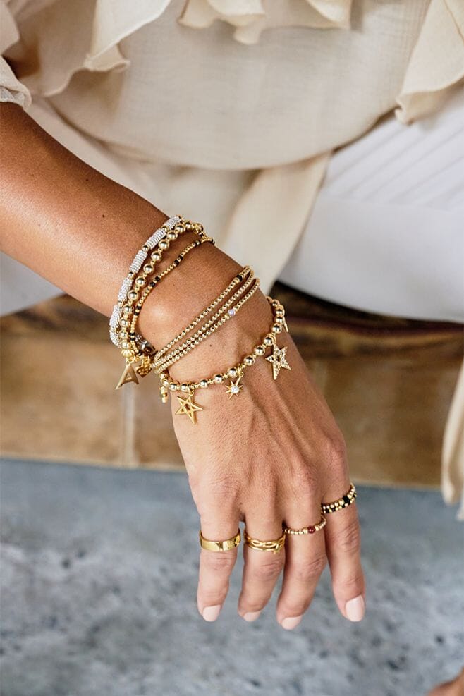 Hand-threaded on high-quality jewellery elastic featuring a gold plated silver Initial charm.