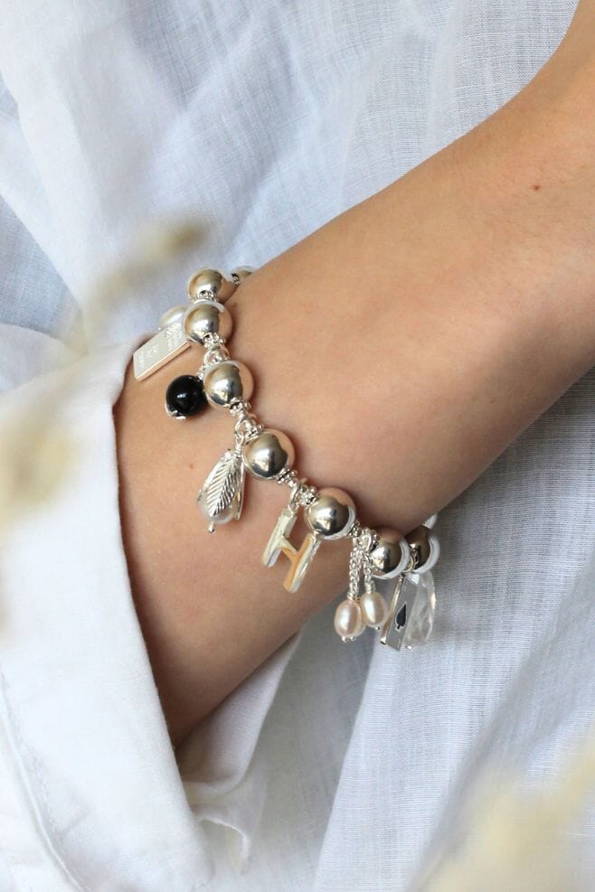 Ten beautiful, eye-catching charms dangle from a chunky 925 Sterling Silver bracelet with 10mm beads.
