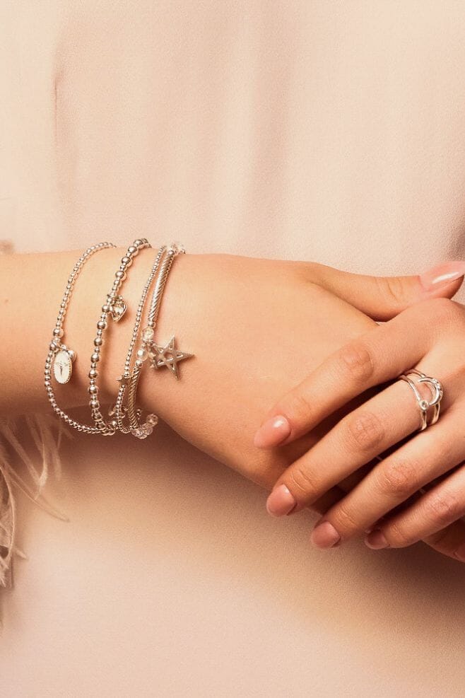 Four strand bracelet stack handcrafted in 925 Sterling Silver, featuring glistening crystals, star and heart charms, and our newest angel charm.