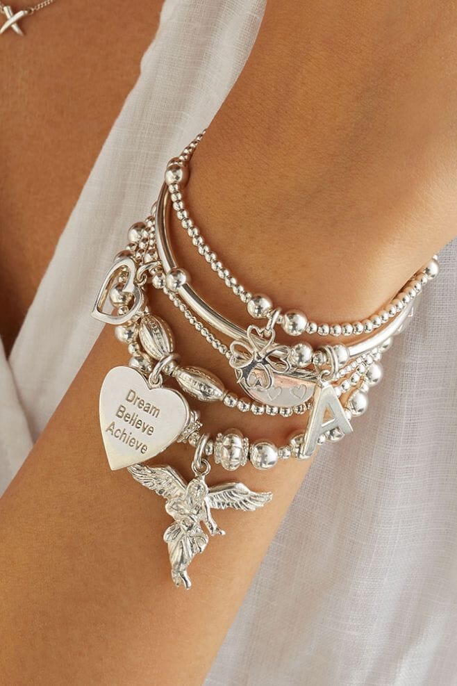 A timeless 5 strand bracelet stack featuring meaningful charms such as the Guardian Angel, choice of initial, and motto charms.