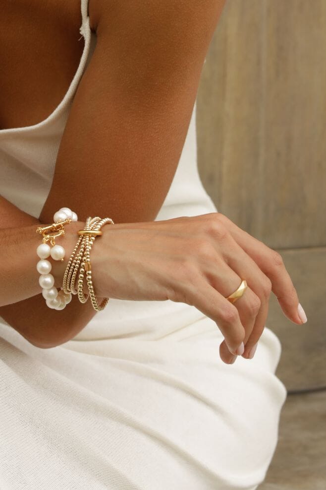 A statement bracelet featuring one long continuous yard of glorious gold graduated beads in a stunning wrap style bracelet. Held together by a heavy binding ring and finished off with an engraved ‘Yard of Love’ bead.