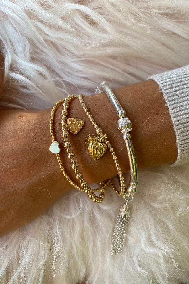 Three strand gold plated 925 Sterling Silver bracelet stack featuring heart shaped charms and a special charm engraved with your choice of motto!