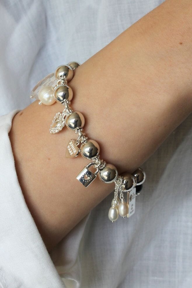 Ten beautiful, eye-catching charms dangle from a chunky 925 Sterling Silver bracelet with 10mm beads.