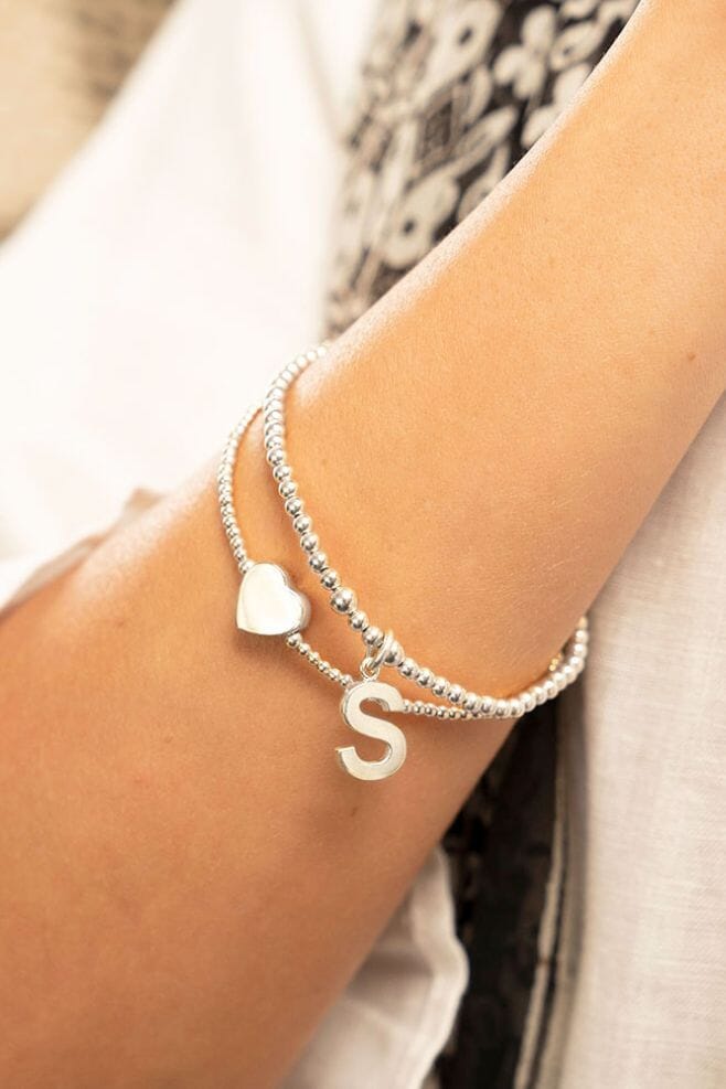 A double strand bracelet is hand-threaded with 925 Sterling Silver beads and your choice of initial.