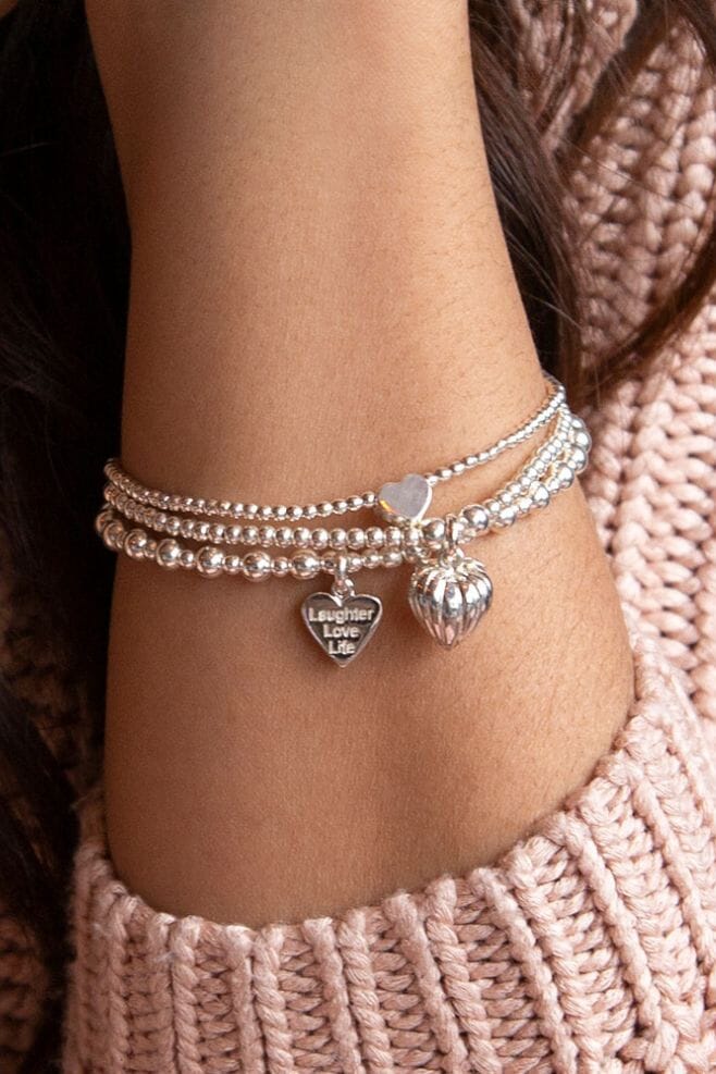Three strand 925 Sterling Silver bracelet stack featuring heart shaped charms and a special charm engraved with your choice of  motto!