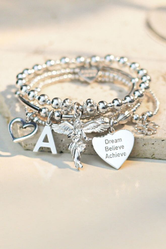 Annie's iconic 925 Sterling Silver 5 strand bracelet stack featuring meaningful charms, including the Guardian Angel and your choice of Initial charm.