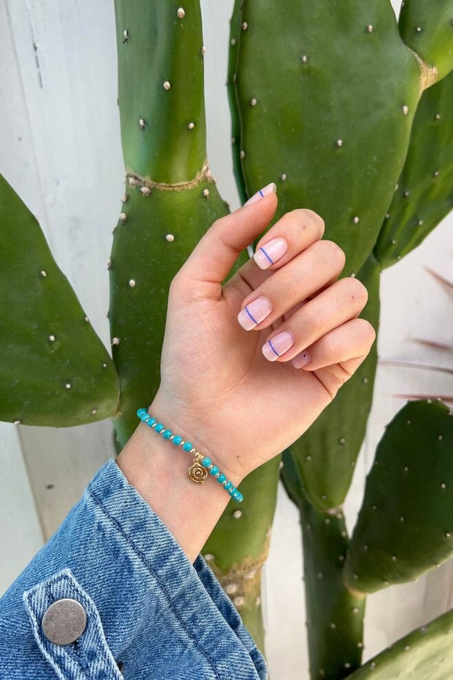 A classic Annie Haak design with a twist. A Mini Orchid featuring turquoise Magnesite, gold plated 925 Sterling Silver beads and a spiral charm.