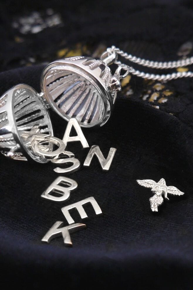 An oval shaped locket that holds a mini ‘My Guardian Angel’ charm in 925 Sterling Silver and a personalised Initial charm.