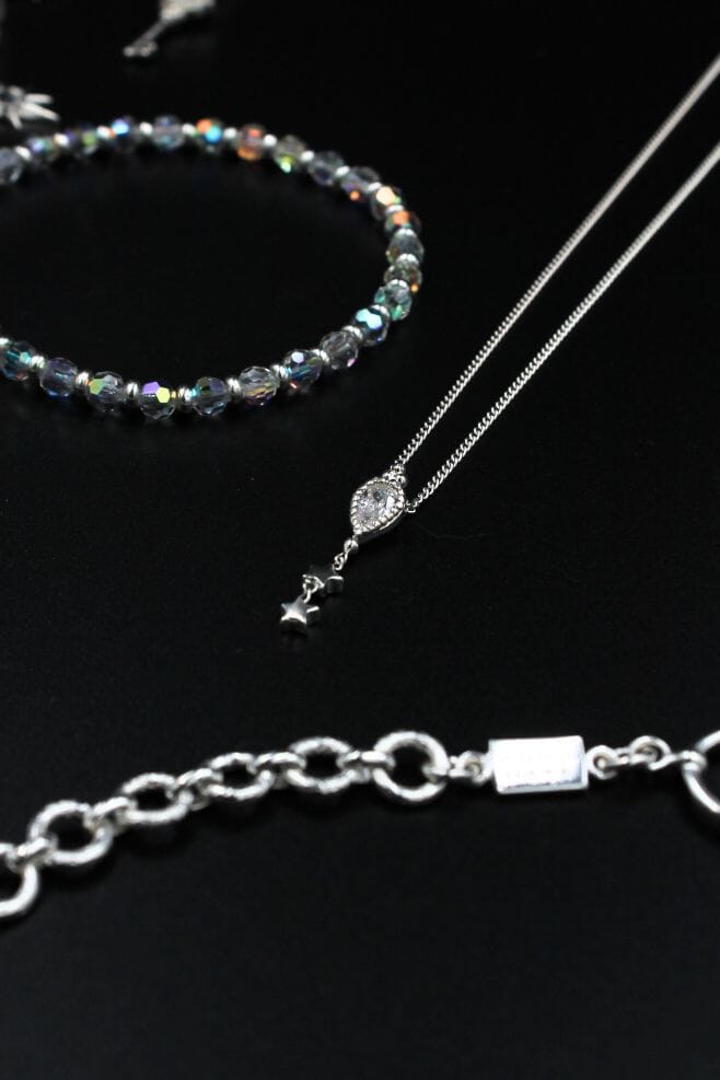 This elegant 925 Sterling Silver necklace features a Crystal Teardrop charm with dainty dangling stars.