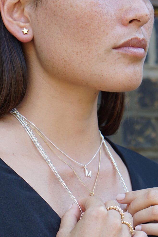 A dainty 925 Sterling Silver necklace with a choice of cute 925 Sterling Silver Tiny Initial charms.
