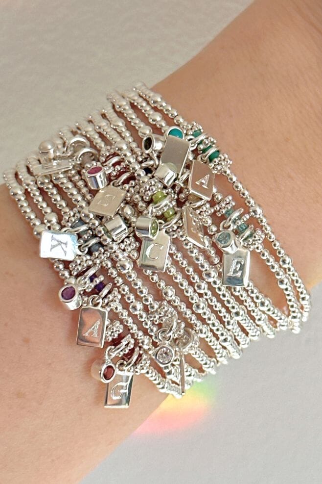 A 925 Sterling Silver stacking bracelet featuring semi-precious birthstone charm and an engraved initial.