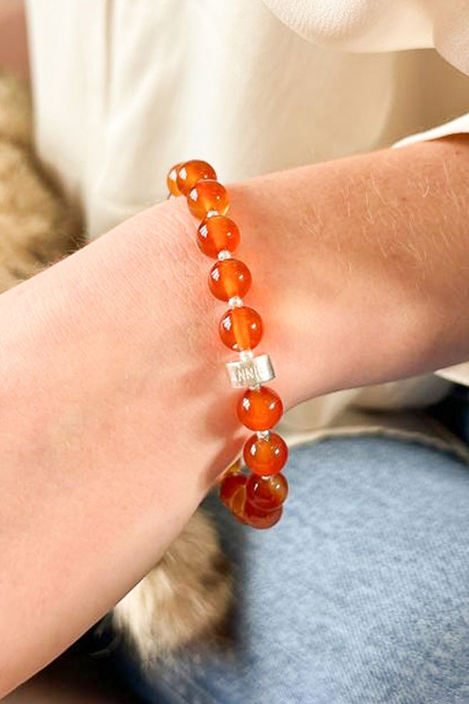 A hand-threaded bracelet featuring genuine Carnelian Red gemstone and 925 Sterling Silver beads.