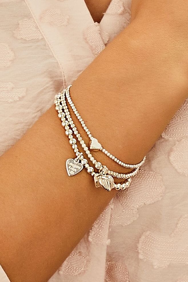 Three strand 925 Sterling Silver bracelet stack featuring heart shaped charms and a special charm engraved with your choice of  motto!