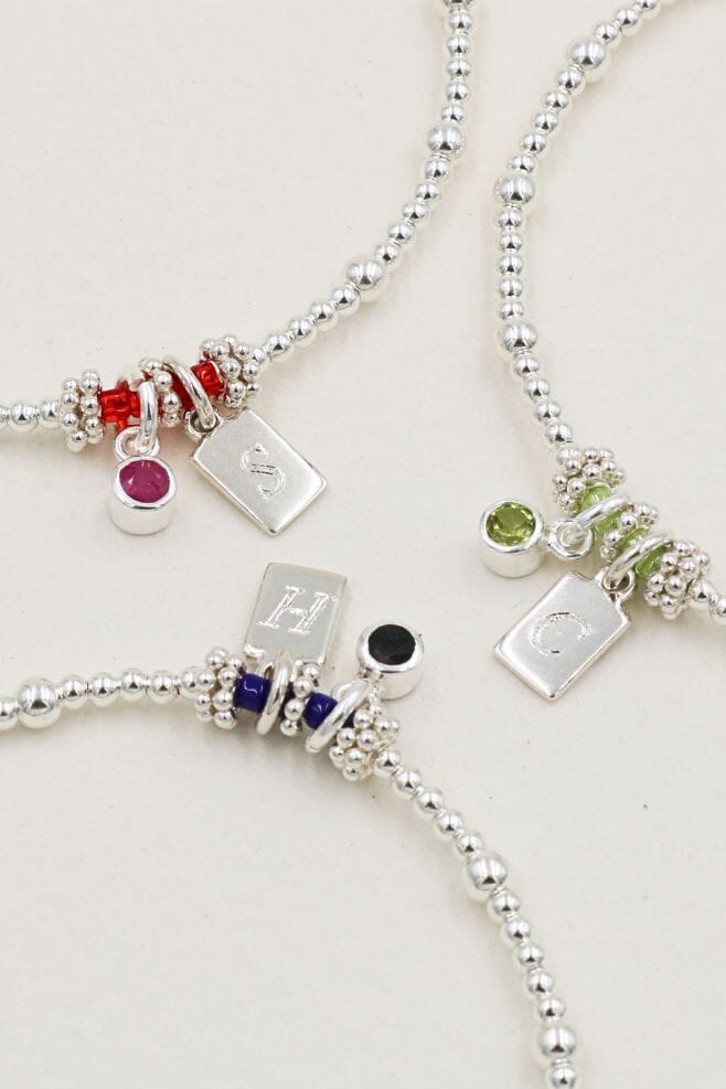 A 925 Sterling Silver stacking bracelet featuring semi-precious birthstone charm and an engraved initial charm.