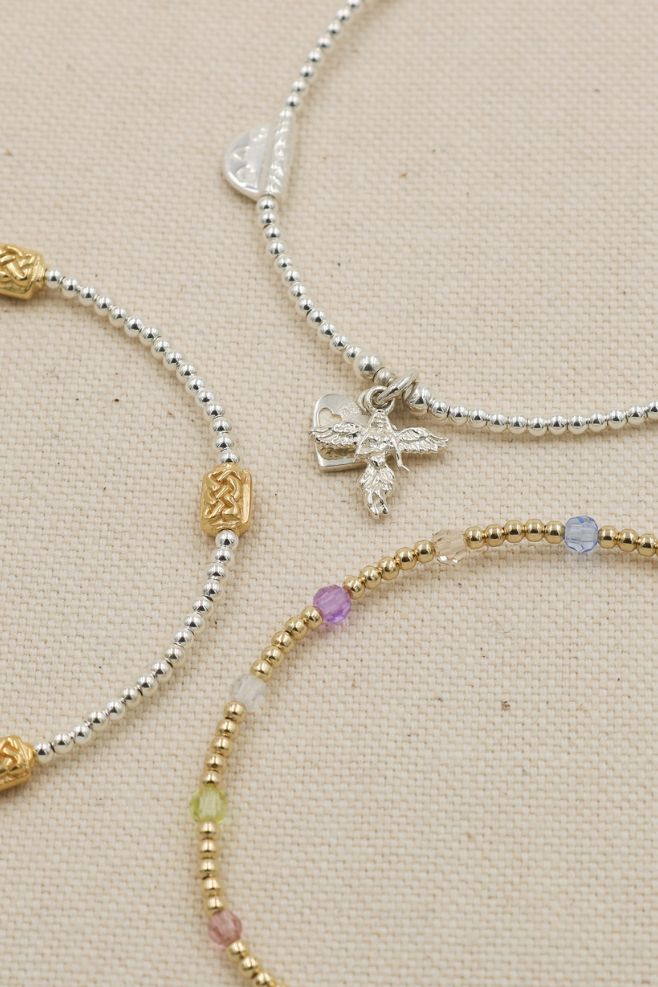 A unique bracelet featuring 925 Sterling Silver beads and intricate gold-plated Lattice patterned oblong charms.