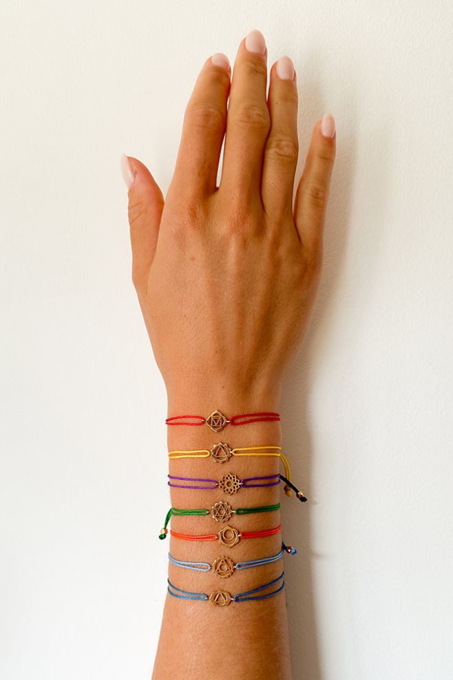 Light blue woven friendship bracelet, featuring a gold-plated Silver Throat Chakra symbol.