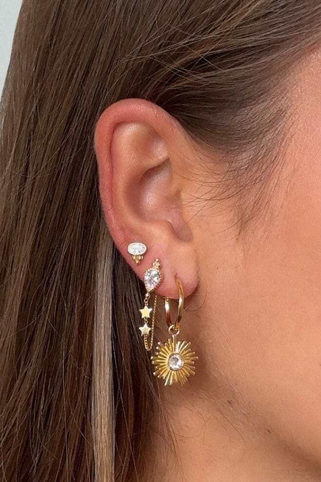 This elegant design features a Crystal Teardrop charm with dainty stars hanging gracefully and a delicate chain that adorns the earlobe.