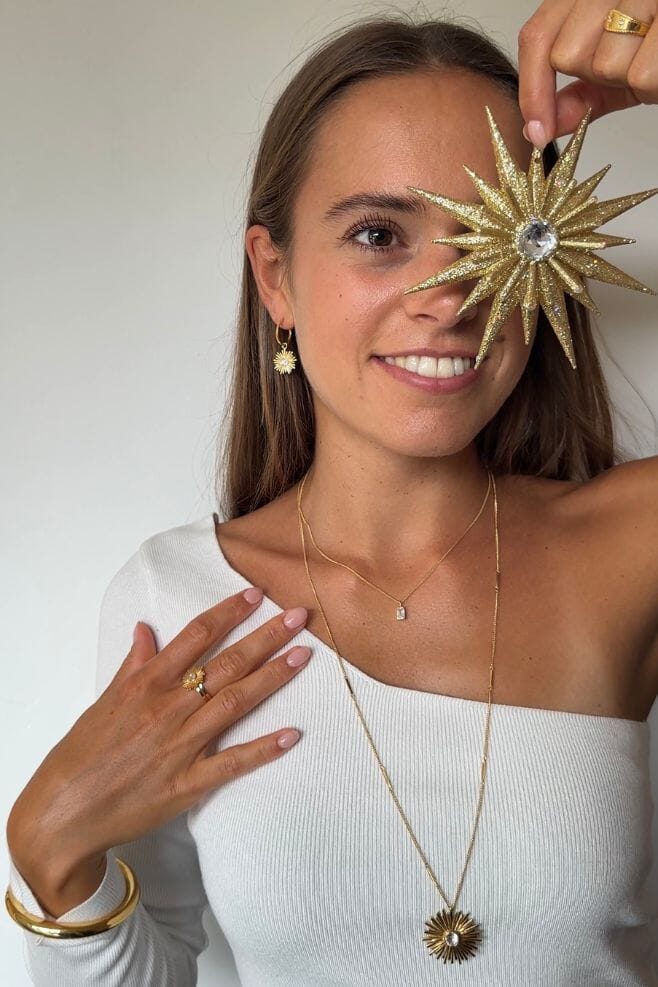 These hoop earrings feature an intricately designed gold plated Sterling Silver starburst detail with a sparkling crystal centrepiece.