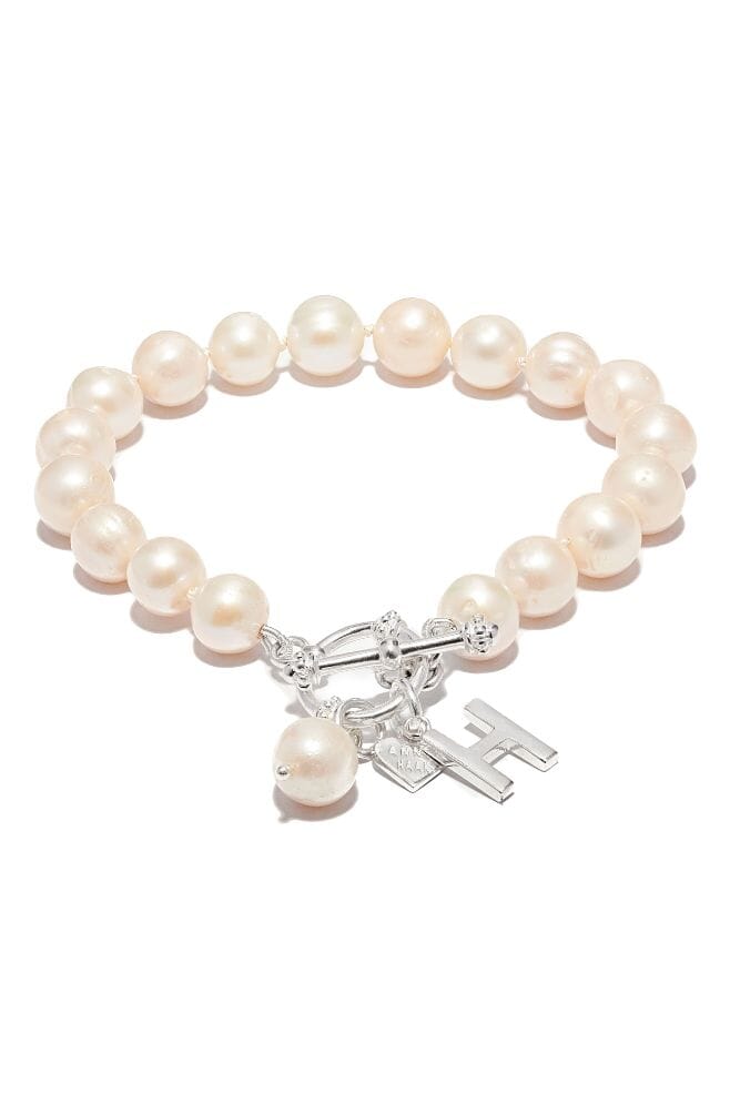 The glamorous Toggle Pearl Bracelet combines decadent Freshwater Pearls and Gold plated Sterling Silver with a stunning T-Bar clasp and initial charm of your choice.