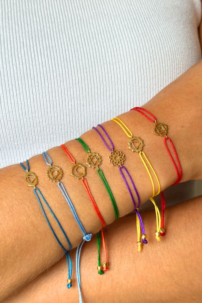 Orange woven friendship bracelet, featuring a gold-plated Silver Sacral Chakra symbol.