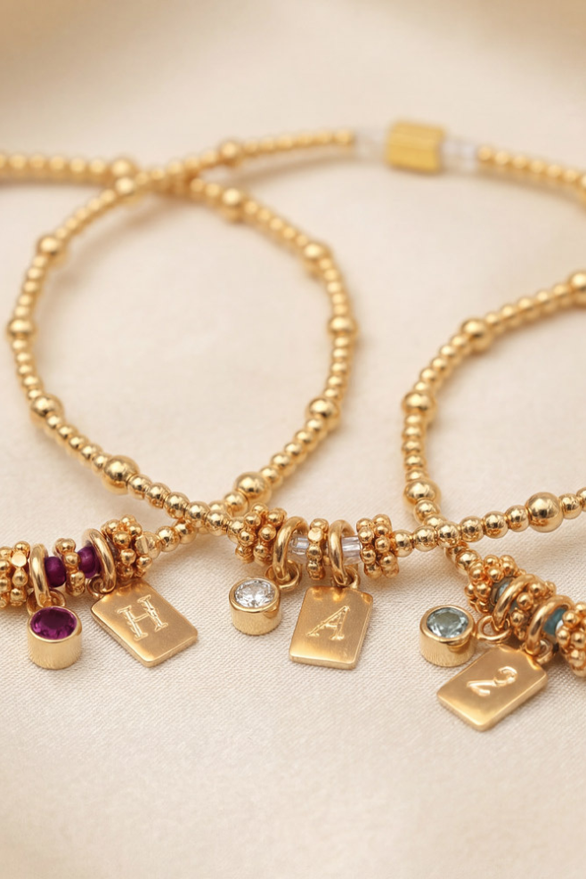 Personalised zodiac tag bracelet with semi-precious birthstone and engraved initial in gold-plated silver.