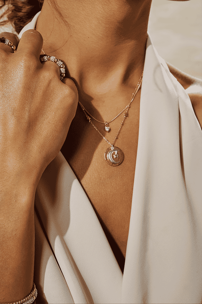 This beautiful gold-plated necklace features a hammered full moon with a facing half-moon with a hanging star.