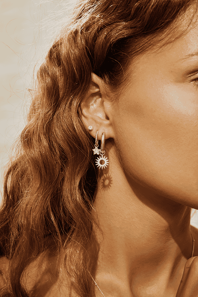 Inspired by the sun, these pretty Sterling Silver hoop earrings with a drop down sun charm symbolise life, energy, positivity and confidence.