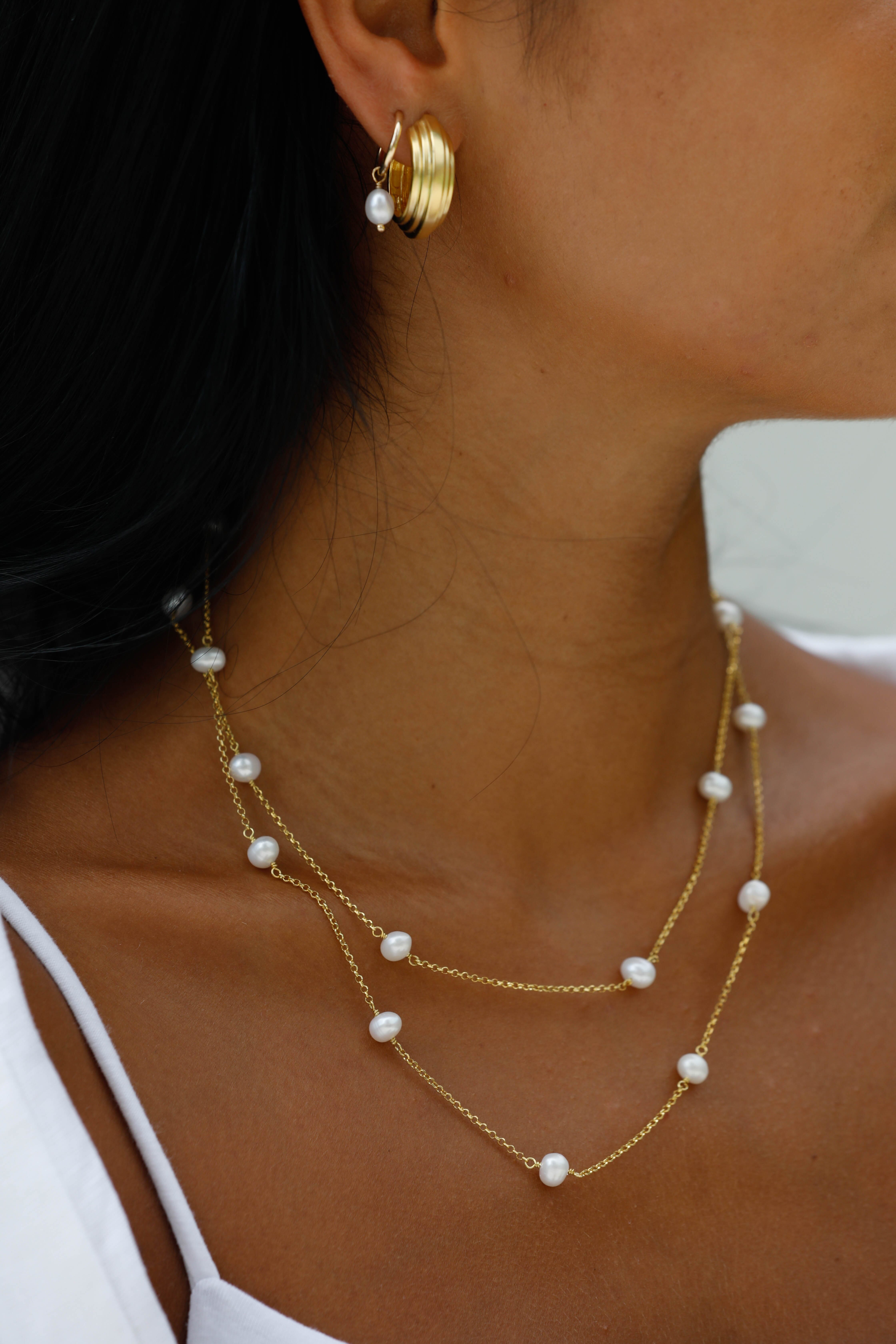 The necklace is a gold duo chain, handcrafted featuring stunning Freshwater Pearls.
